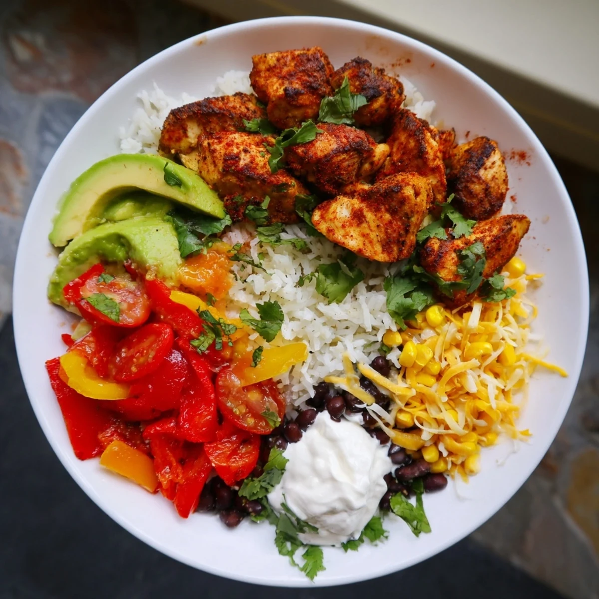 Vibrant sheet pan chicken burrito bowls, overflowing with colorful roasted vegetables and savory seasoned chicken.