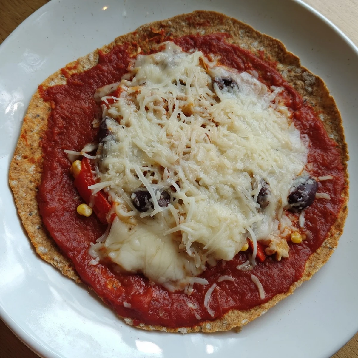 Crispy tortilla pizza, showcasing a quick, easy meal with mozzarella cheese and black olives, so delicious.
