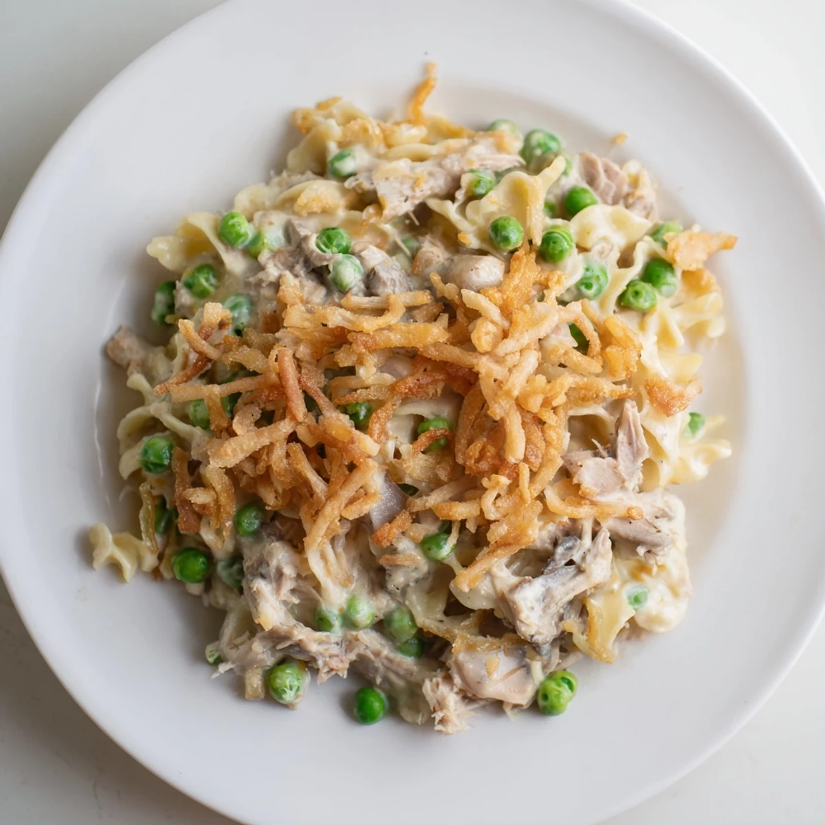 Golden-brown homemade tuna noodle casserole with a crispy onion topping ready to serve.