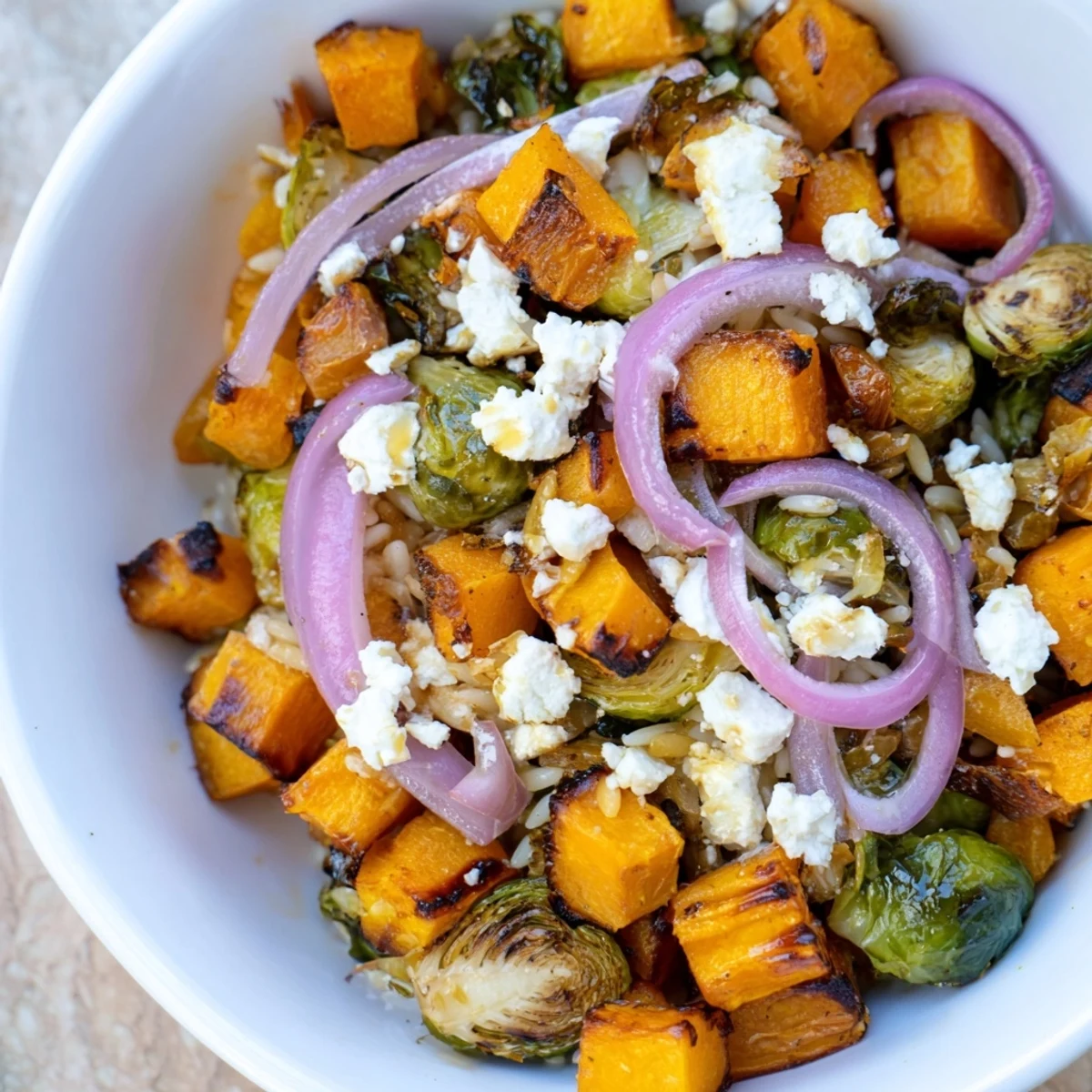 A beautiful bowl of Best Fall Harvest Orzo Salad with roasted vibrant vegetables, ready to eat.