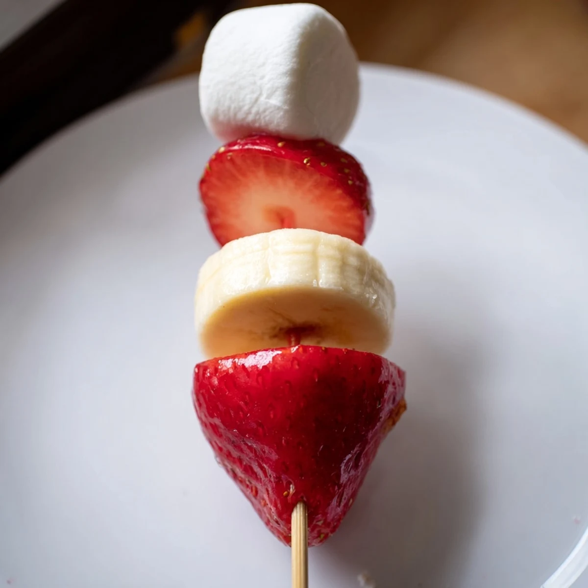 Red strawberry halves and banana slices create adorable Strawberry Banana Santa Sticks for holiday snacking.