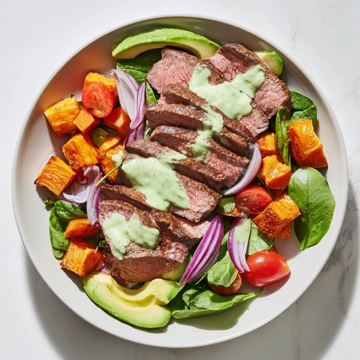 This healthy Beef Avocado Sweet Potato Bowl features fresh avocado slices and tangy lime dressing.