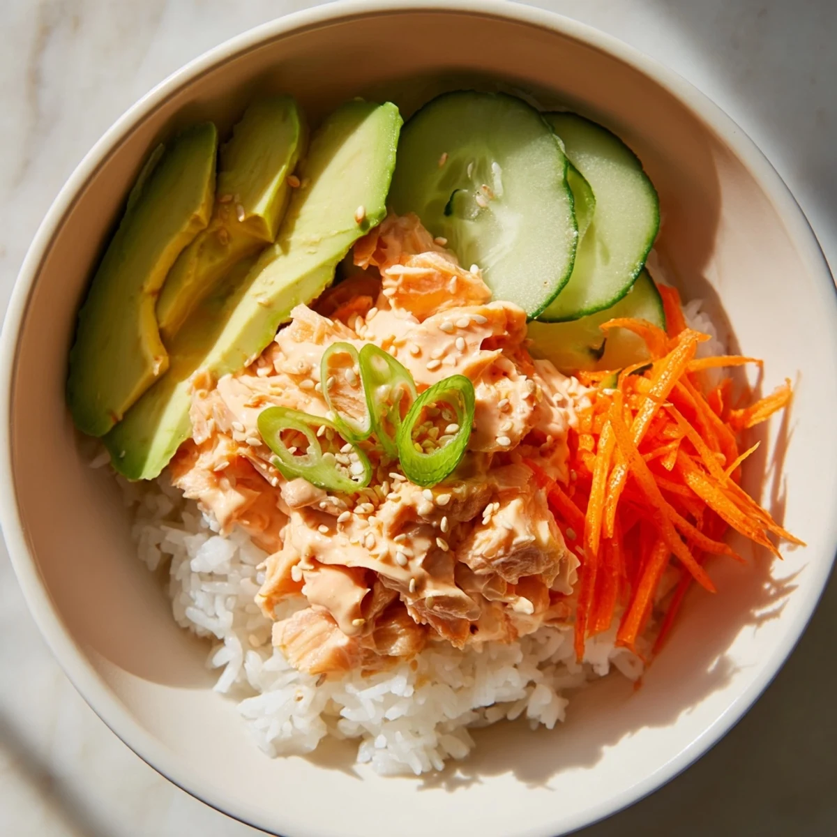 Vibrant Spicy Canned Salmon Rice Bowl with avocado and sesame seeds, a quick, satisfying meal.
