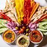 A visually stunning photo of The Moroccan Tent appetizer, with fresh veggies artfully arranged for dipping.