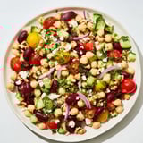 A visually appetizing bowl of Dense Bean Salad, featuring mixed beans and fresh cherry tomatoes.