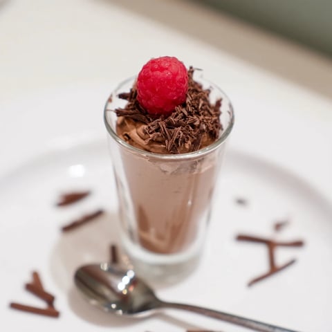 Rich, dark chocolate mousse dessert cups, chilled to perfection, topped with fresh berries and chocolate shavings.