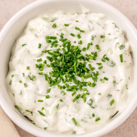 Creamy Veggie Ranch Dip topped with green chives and served with colorful fresh vegetables.