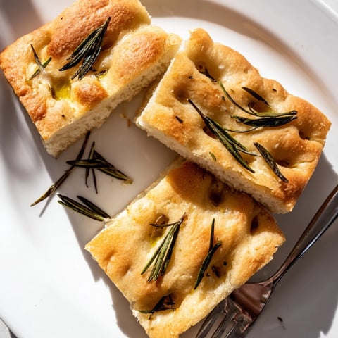Golden Holiday Bread focaccia, sliced, topped with fragrant rosemary and flaky sea salt.