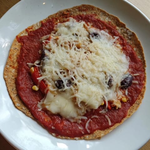 Crispy tortilla pizza, showcasing a quick, easy meal with mozzarella cheese and black olives, so delicious.
