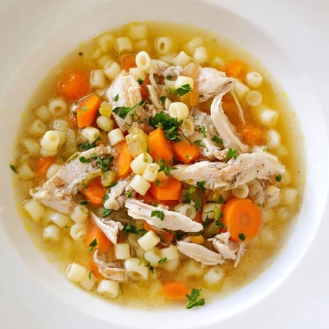 Golden broth swirling with ditalini in a bowl of Chicken and Ditalini Flu Fighter Soup.