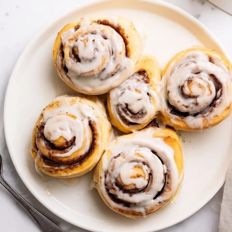 Warm Pillow Soft Cinnamon Rolls with buttery cinnamon swirls and rich cream cheese frosting.