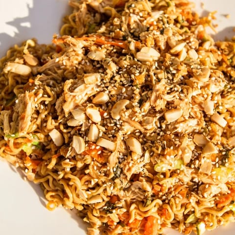 A vibrant Crunchy Ramen Chicken Salad served fresh, showcasing colorful carrots and scallions for a quick, crowd-pleasing potluck dish.