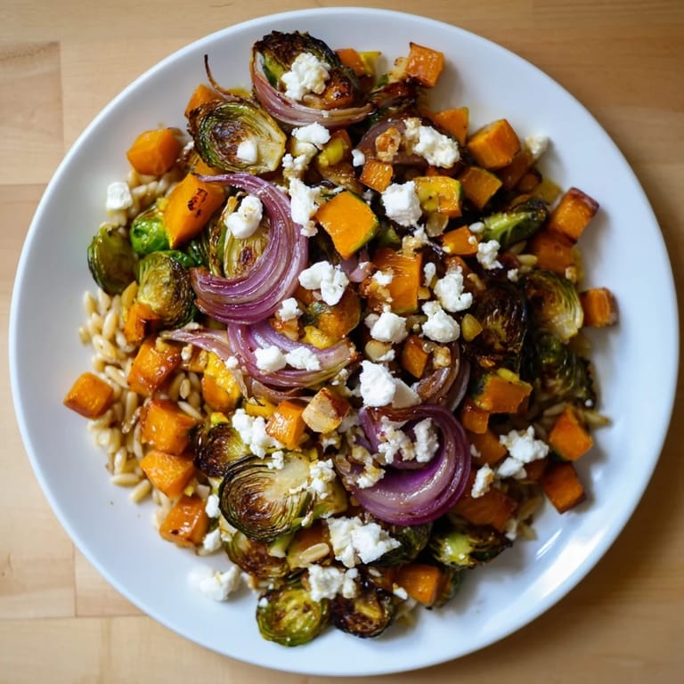 Tangy goat cheese tops a delicious, warm serving of Best Fall Harvest Orzo Salad, perfect for fall.