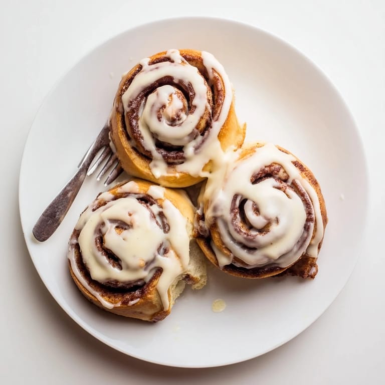 Golden Pillow Soft Cinnamon Rolls served on a plate, ideal for cozy morning gatherings.